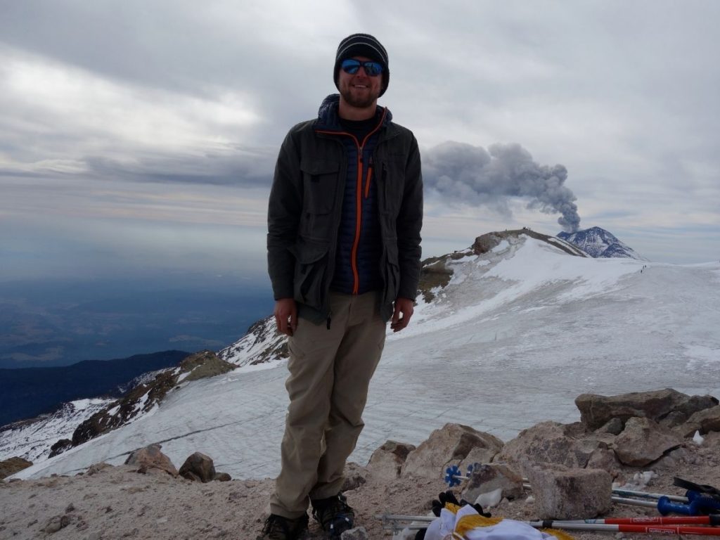 On the summit of Iztaccíhuatl (5,240 m / 17,160 ft) with the active Popocatépetl looming in the background.