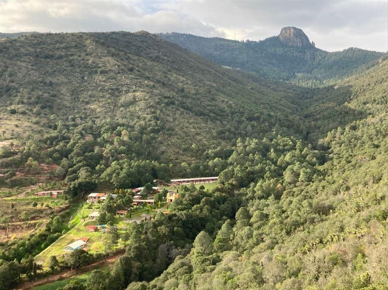 Rancho Escondido Casa Goyri provides eco-friendly cabañas and meals while immersed in the gorgeous forests beneath the ominous rock formation, La Peña del Rosario. Photo from La Mirador, just a 15-minute hike from the cabañas.