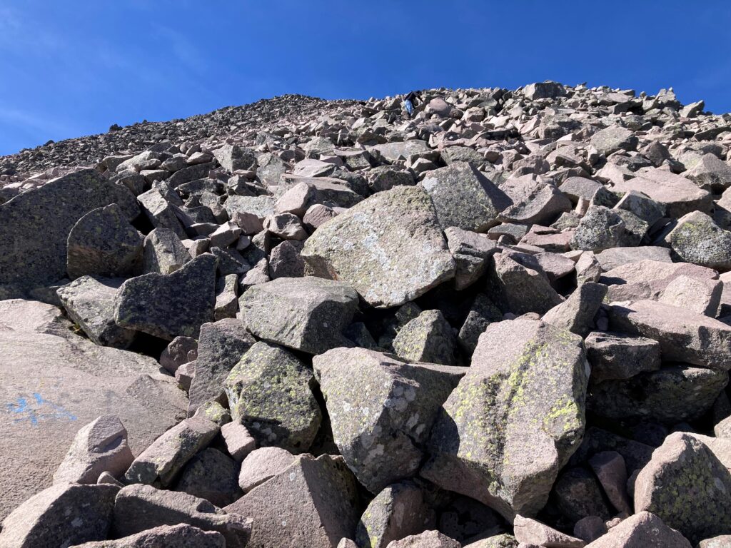 A steep slope of large, gray rocks are pretty much the last difficult part before the summit.